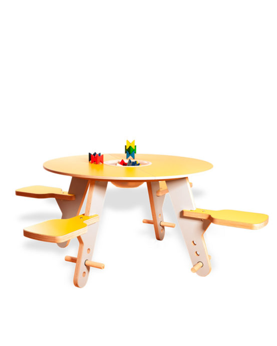 Novosan Timkid Tavi-pöytäryhmä lapsille. Pöytä ja kiinteiden istuimien istuinosat ovat kirkkaan keltaiset. Lasten leikkipöydällä on värikkäitä puupalikoita.